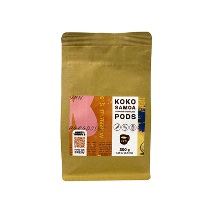 A stand-up kraft paper pouch of 200g Koko Samoa pods on a plain white background. The pouch is a warm tan/kraft color with a large front label featuring pink, orange, white, and blue graphic elements and text including &