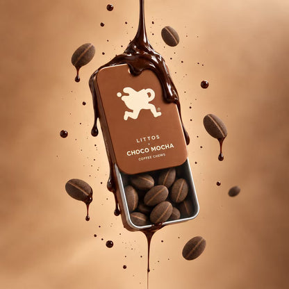 A rectangular tin of LITTOS Choco Mocha coffee sits centered on a warm brown background, surrounded by floating coffee beans and glossy chocolate drizzle. The tin label is brown with a white running dog logo and the text &