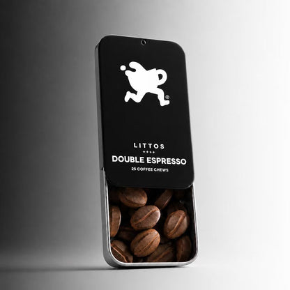 A silver metal tin of LITTOS Double Espresso coffee chews, with the black lid partially slid off to reveal dark roasted coffee beans inside, set against a clean gray gradient background.
